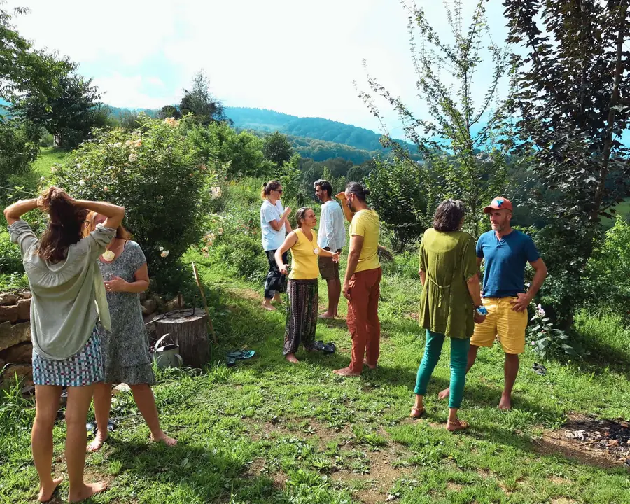 A circle of people in the garden, facing the Pyrenees