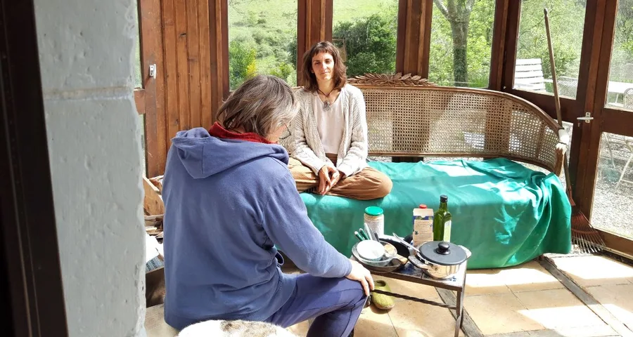 Two people sitting face to face in the veranda, listening to each other