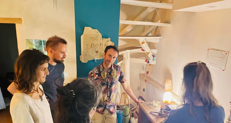 A group gathered around a workbench, in front of drawings pinned to the wall